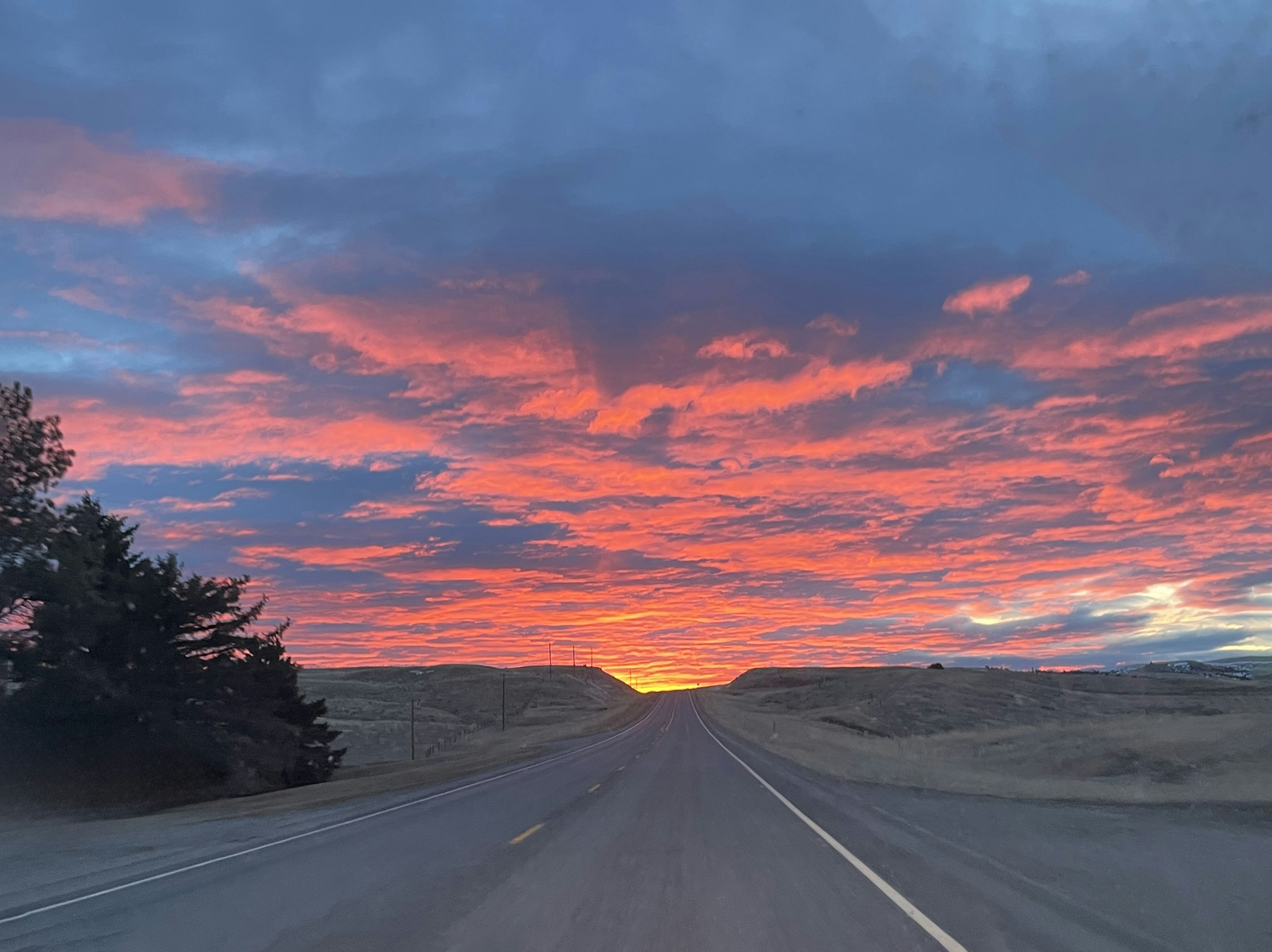 An Indian highway stretching toward a fiery sunset sky